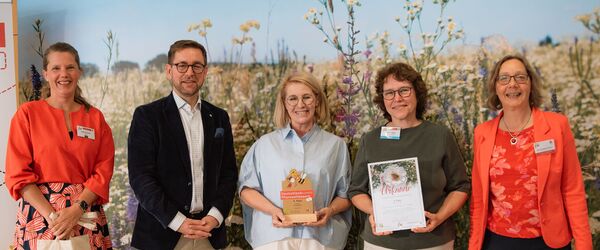 Deutschland summt!-Pflanzwettbewerb 2025: Stiftungsleiterin Dr. Corinna Hölzer (re.), Wettbewerbsleiterin Julia Sander (li.) und Staatssekretär Andreas Kraus (2. v. li.) ehren die Tagespflege der Stiftung St. Ludgeri mit einem 3. Platz.